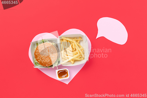 Image of I love fast food. French fries in the form of heart isolated on red background