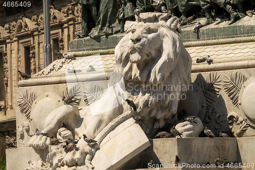 Image of Lion statue and doves near cathedral