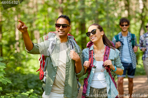 Image of group of friends with backpacks hiking in forest