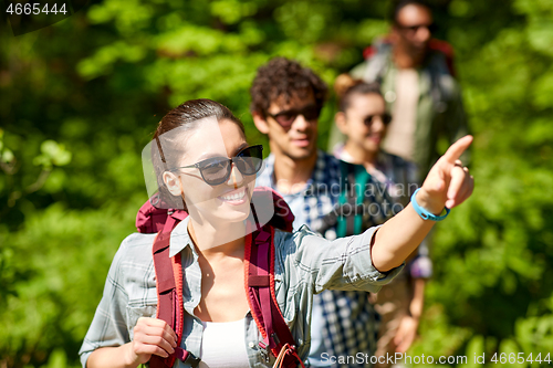 Image of group of friends with backpacks hiking in forest