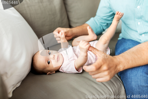 Image of middle aged father playing with baby at home