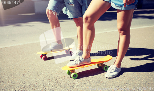 Image of teenage couple riding skateboards on city street