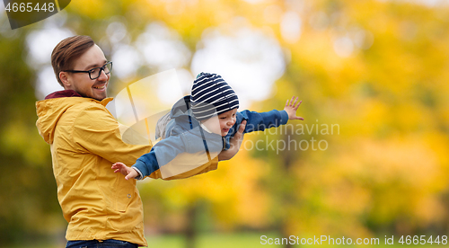 Image of father with son playing and having fun in autumn