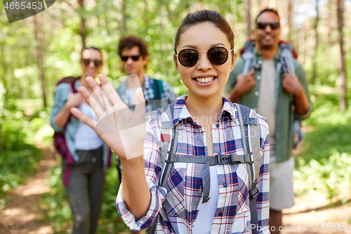 Image of friends with backpacks on hike in forest