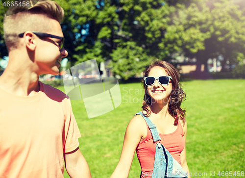 Image of happy teenage couple walking at summer park