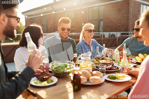 Image of friends having dinner or bbq party on rooftop