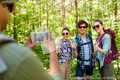 Image of friends with backpacks being photographed on hike