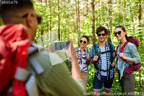 Image of friends with backpacks being photographed on hike