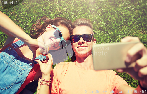 Image of happy couple taking selfie on smartphone at summer