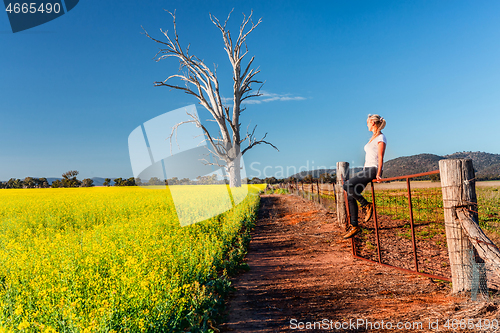 Image of Country woman basking in the spring sunshine looking out over th