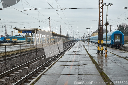 Image of Railway station with passaenger trains in rain