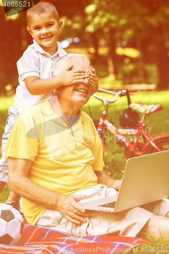 Image of grandfather and child using laptop