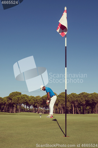 Image of golf player hitting shot at sunny day