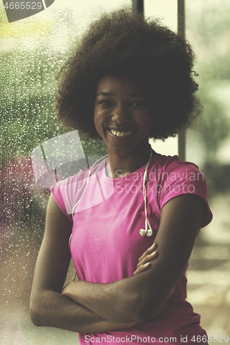 Image of portrait of young afro american woman in gym while listening mus