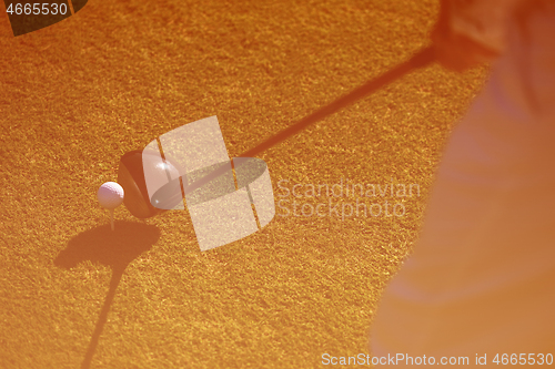 Image of top view of golf club and ball in grass