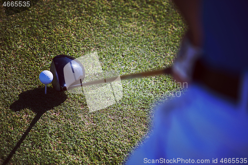 Image of top view of golf club and ball in grass