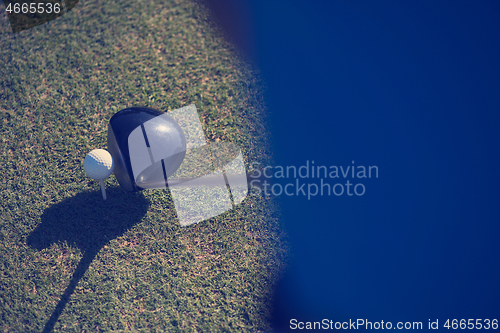 Image of top view of golf club and ball in grass