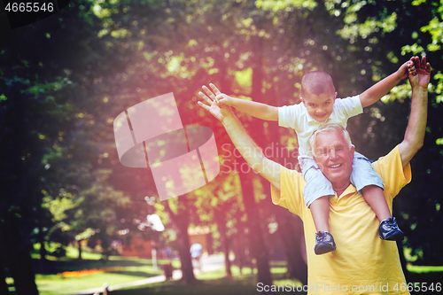 Image of grandfather and child have fun  in park