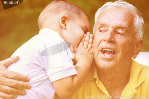 Image of grandfather and child have fun  in park