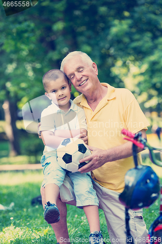Image of grandfather and child have fun  in park