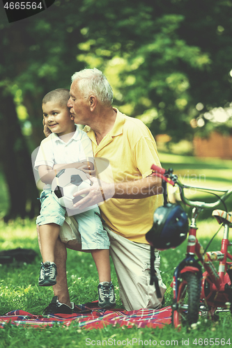 Image of grandfather and child have fun  in park