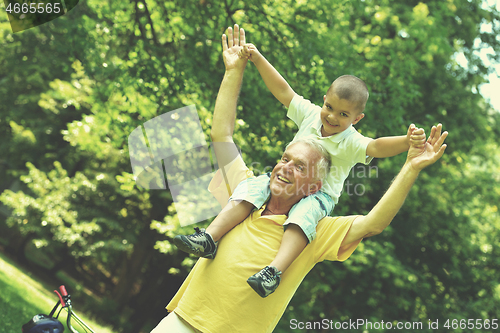 Image of happy grandfather and child in park