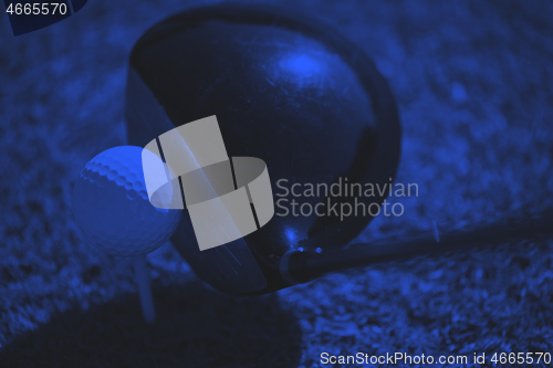 Image of top view of golf club and ball in grass