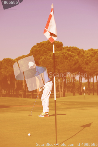 Image of golf player hitting shot at sunny day