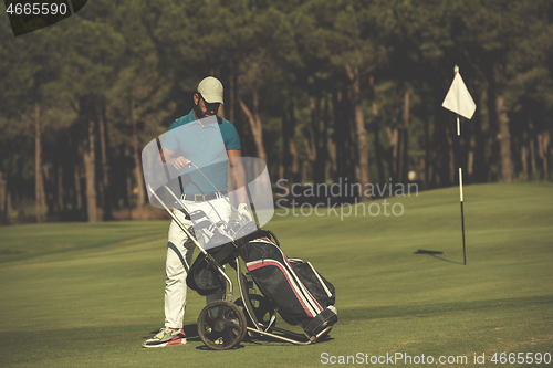 Image of golf player walking with wheel bag