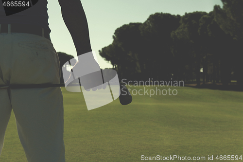 Image of golf player close up hand and driver from back