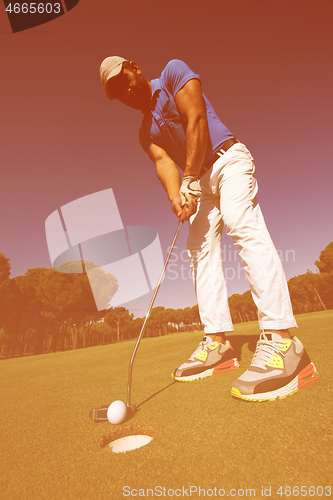 Image of golf player hitting shot at sunny day, wide angle lens