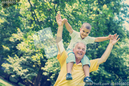 Image of grandfather and child have fun  in park