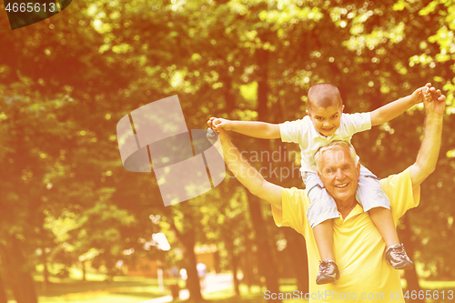 Image of grandfather and child have fun  in park