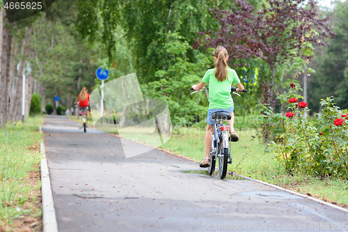 Image of Girl rides on a special bike path in a city park