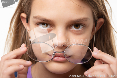 Image of Closeup portrait of a girl who took off round glasses