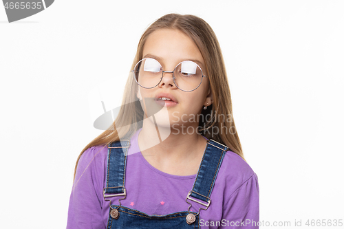 Image of Portrait of a girl in glare glasses trying to look at her nose