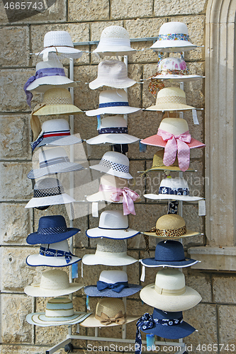 Image of A lot of various women's hats in the street shop