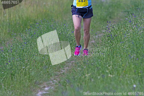 Image of Young woman running in nature on a rural road 