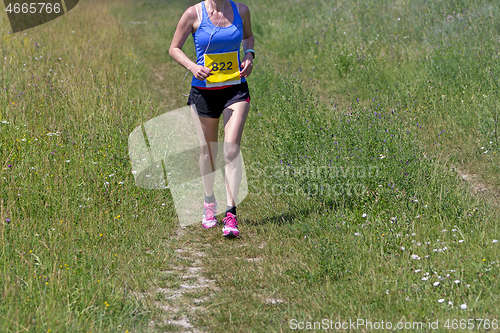 Image of Young woman running in nature on a rural road 