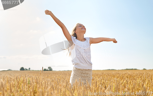 Image of happy smiling young girl on cereal field in summer