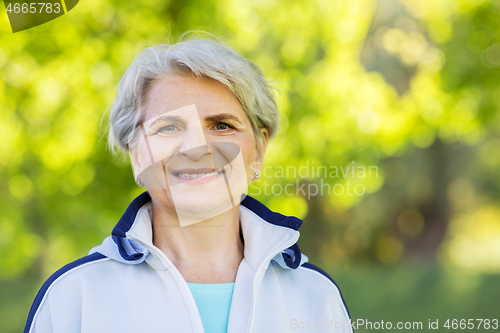 Image of smiling sporty senior woman at summer park