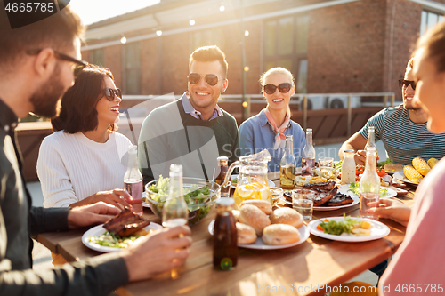 Image of friends having dinner or bbq party on rooftop