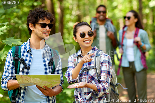Image of friends with map and backpacks hiking in forest