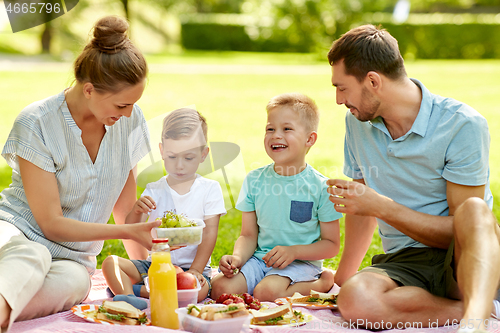 Image of happy family having picnic at summer park