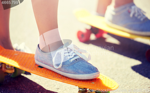 Image of close up of feet riding skateboards on city street