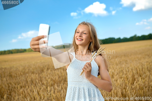 Image of happy young girl taking selfie by smartphone