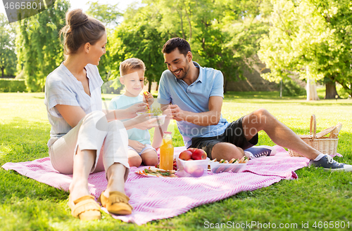 Image of happy family having picnic at summer park