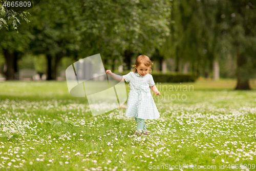 Image of happy little baby girl at park in summer