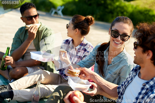 Image of friends hiking and having picnic on lake pier