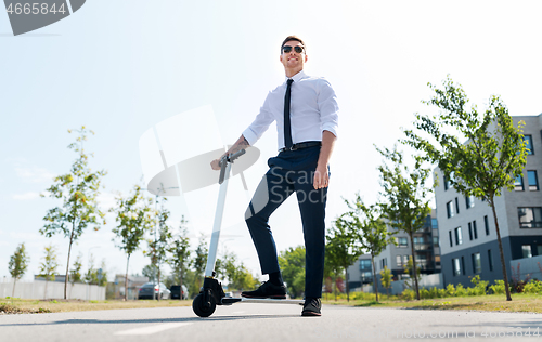 Image of young businessman riding electric scooter outdoors